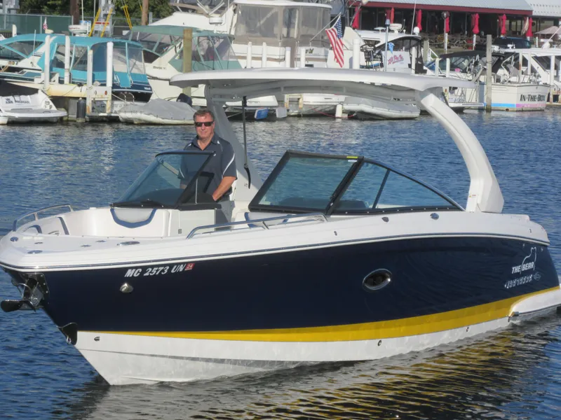 Slide: The Image of 2021 Chaparral 307 SSX boat on water with a person at the helm. - 3