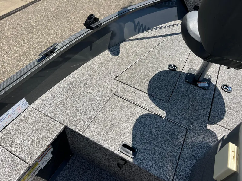 Slide: The Image of 2021 MirroCraft 145 Side Console boat interior with gray flooring and seating. - 10