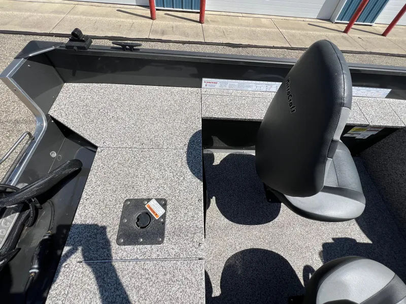 Slide: The Image of 2021 MirroCraft 145 Side Console boat interior with seating and storage compartments. - 12