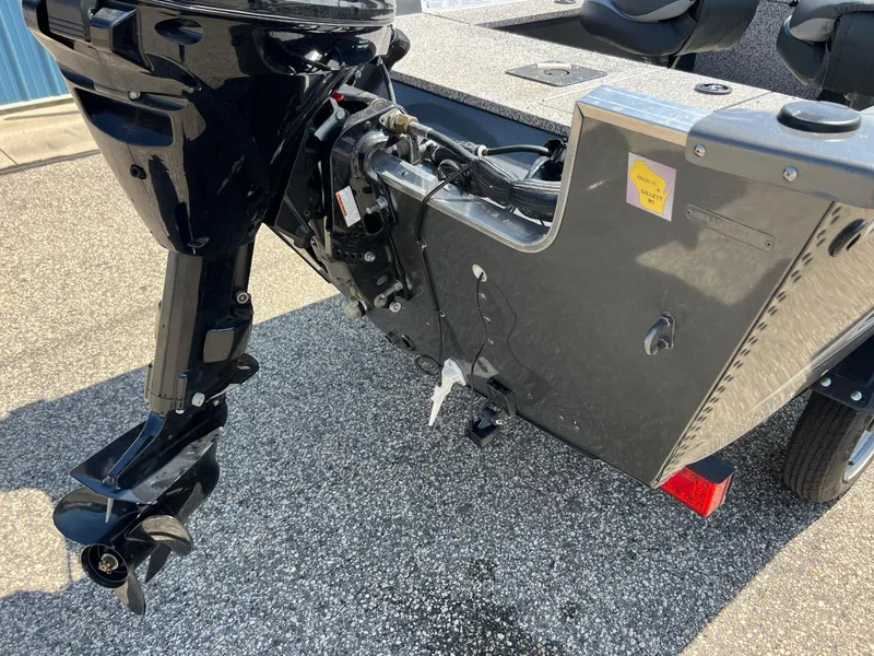 Slide: The Image of 2021 MirroCraft 145 Side Console boat with outboard motor, parked on asphalt. - 5