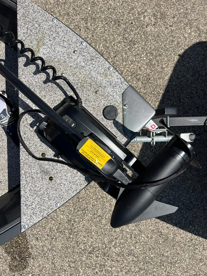 Slide: The Image of 2021 MirroCraft 145 Side Console boat with trolling motor on textured surface. - 6