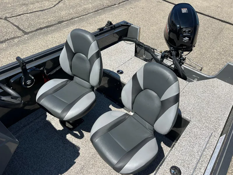 Slide: The Image of 2021 MirroCraft 145 Side Console boat interior with two seats and a Suzuki outboard motor. - 7