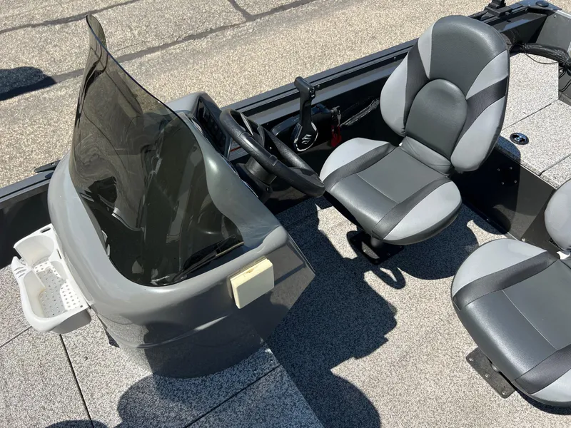 Slide: The Image of 2021 MirroCraft 145 Side Console boat interior with steering wheel and seats. - 8