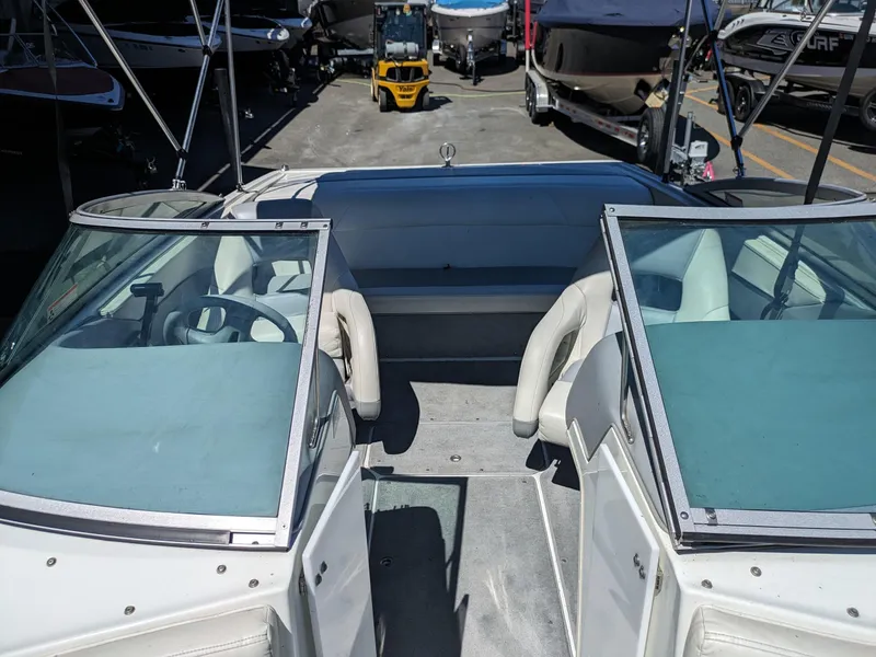 Slide: The Image of 1998 Cobalt 200 boat interior with dual windshields and seating, parked among other boats. - 10