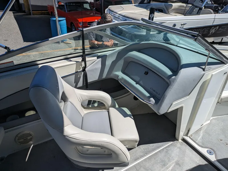 Slide: The Image of Interior of a 1998 Cobalt 200 boat with white seating and dashboard. - 12
