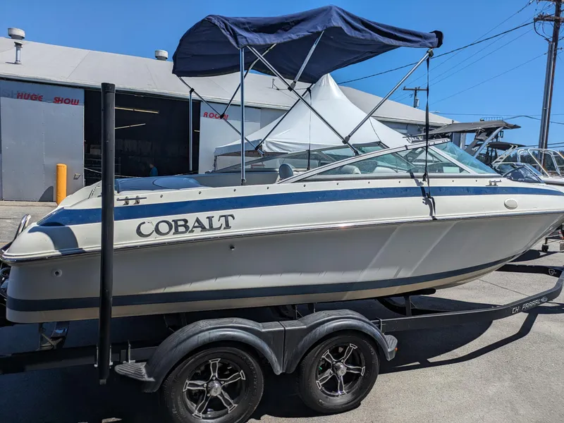 Slide: The Image of 1998 Cobalt 200 boat with canopy on trailer, parked outdoors. - 3
