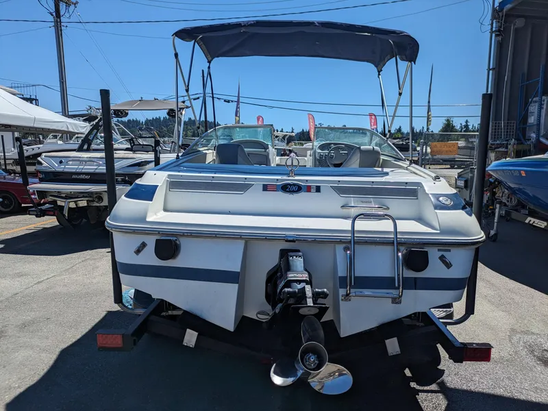 Slide: The Image of 1998 Cobalt 200 boat with canopy, displayed on a trailer in a marina. - 6