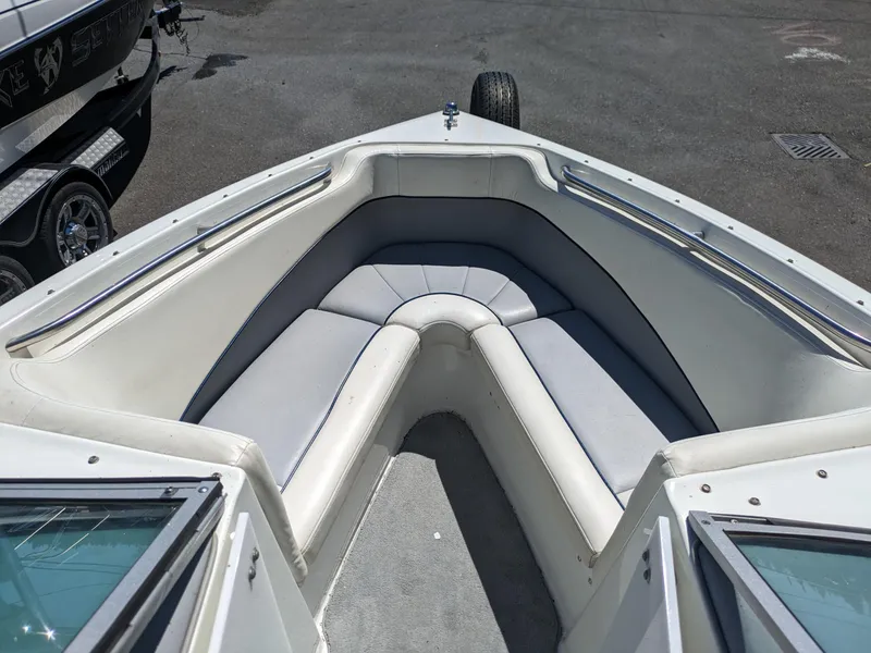 Slide: The Image of Bow seating area of a 1998 Cobalt 200 boat with gray cushions. - 8