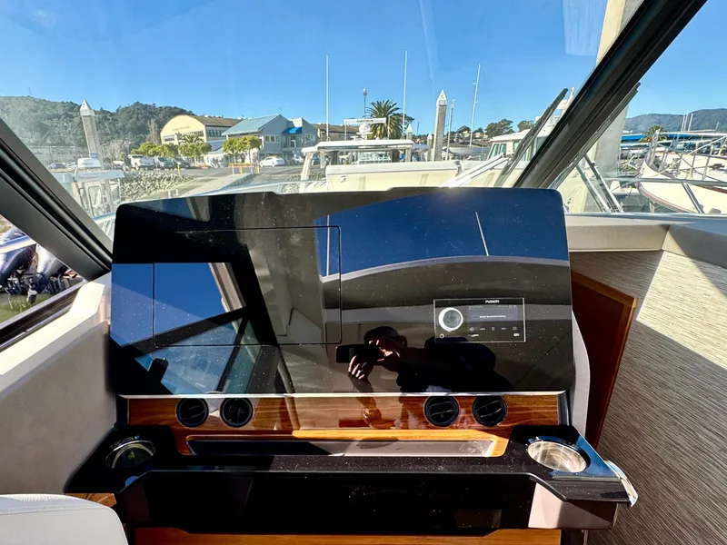 Slide: The Image of 2025 Tiara Yachts 43 LE helm with modern dashboard and marina view. - 23