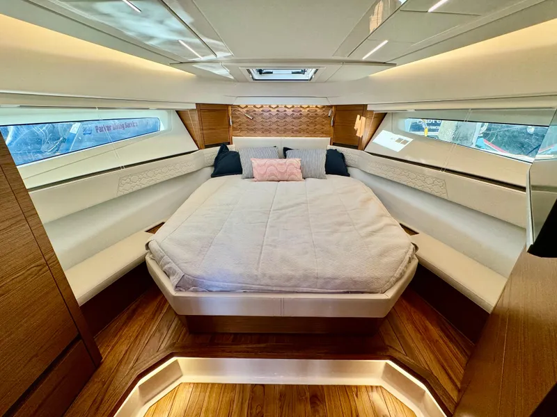 Slide: The Image of Luxurious 2025 Tiara Yachts 43 LE cabin interior with elegant bedding and wood accents. - 25
