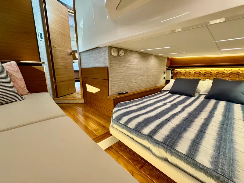 Slide: The Image of Luxurious cabin interior of 2025 Tiara Yachts 43 LE with striped bedding and modern design. - 35