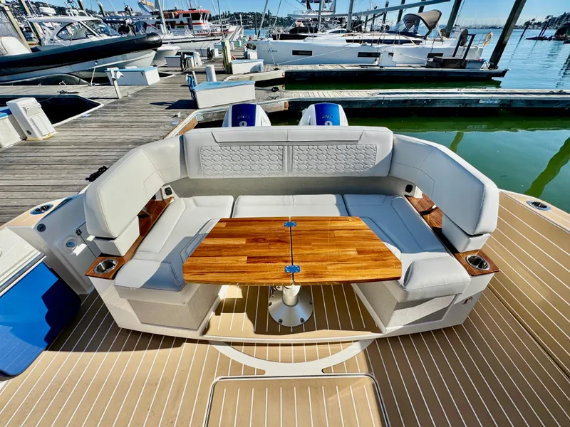 Slide: The Image of Luxurious seating area on 2025 Tiara Yachts 43 LE, featuring elegant wood table and marina backdrop. - 38