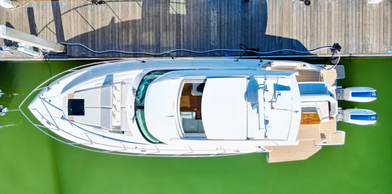 Slide: The Image of 2025 Tiara Yachts 43 LE docked, aerial view, showcasing sleek design and twin engines. - 8