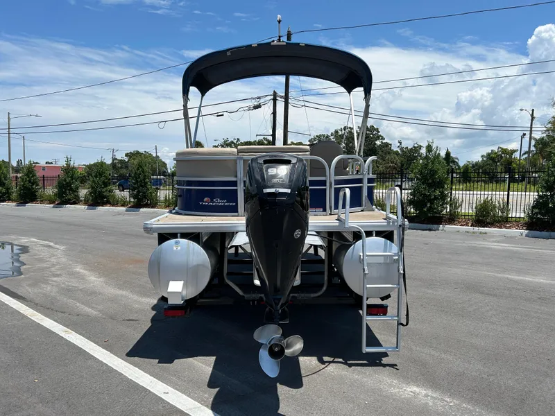 Slide: The Image of 2018 Sun Tracker Party Barge 20 DLX pontoon boat with outboard motor in parking lot. - 2