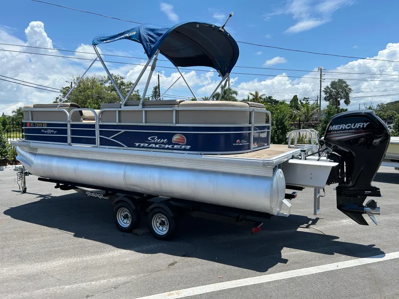 Slide: The Image of 2018 Sun Tracker Party Barge 20 DLX pontoon boat with Mercury outboard motor, parked outdoors. - 3