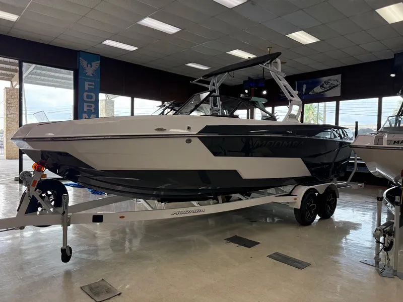The Image of 2025 Moomba Tykon boat displayed indoors on a trailer, showcasing sleek design and modern features. - 1