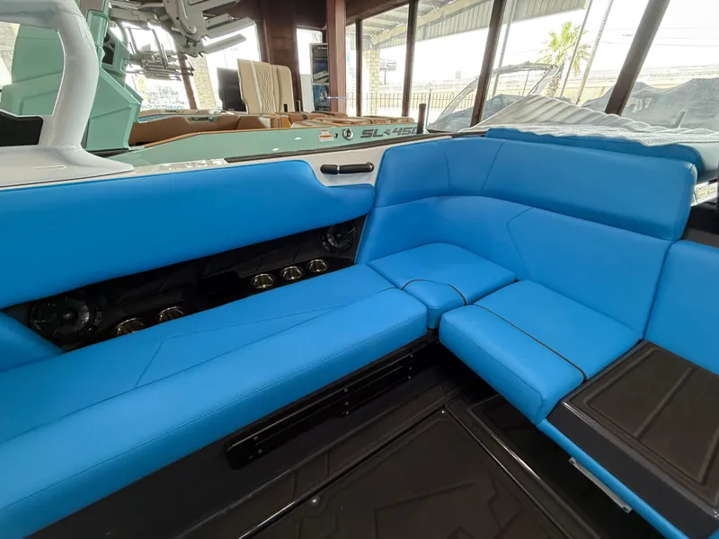 Slide: The Image of 2025 Moomba Tykon boat interior with vibrant blue seating and modern design. - 13