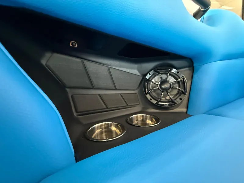 Slide: The Image of 2025 Moomba Tykon interior with blue upholstery, speaker, and cup holders. - 16