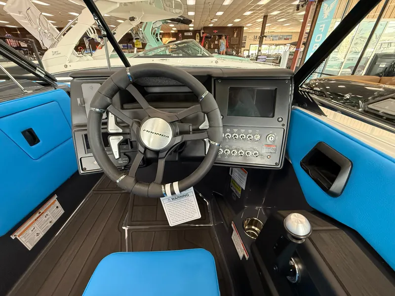 Slide: The Image of 2025 Moomba Tykon boat interior with steering wheel and control panel. - 17