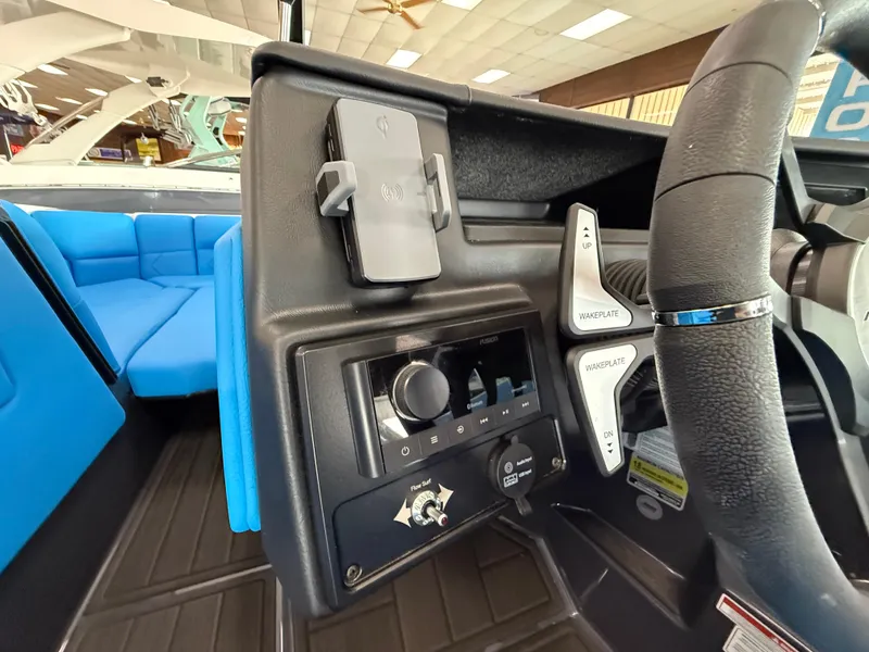 Slide: The Image of 2025 Moomba Tykon dashboard with steering wheel, controls, and blue seating. - 19