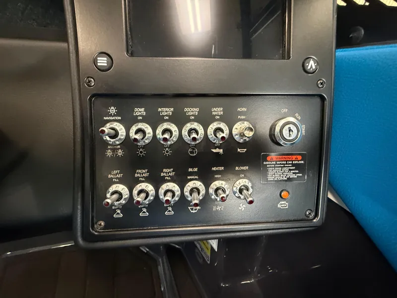 Slide: The Image of Control panel of 2025 Moomba Tykon boat with various switches and ignition key. - 20