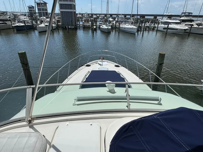Slide: The Image of 1998 Maxum 4600 SCB yacht docked at marina, surrounded by other boats. - 12
