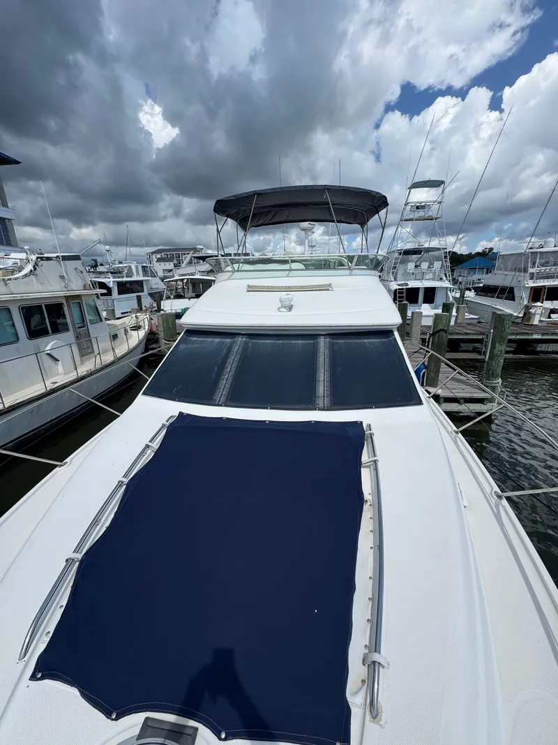 Slide: The Image of 1998 Maxum 4600 SCB yacht docked at marina under cloudy sky. - 15