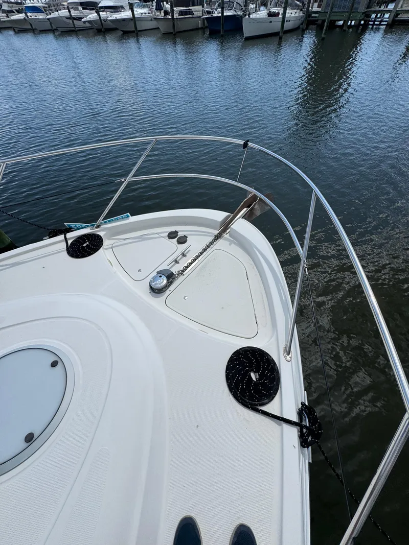 Slide: The Image of Bow of 1998 Maxum 4600 SCB yacht docked in marina, featuring anchor and railing. - 16