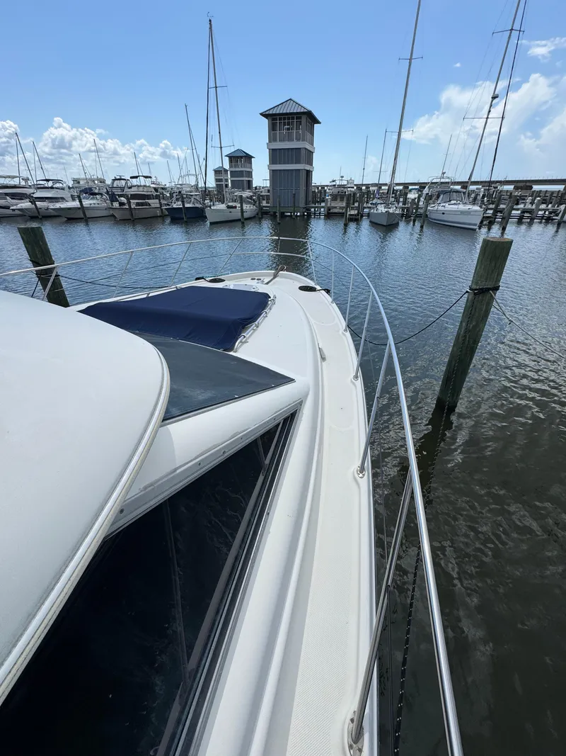 Slide: The Image of 1998 Maxum 4600 SCB yacht docked at a marina with sailboats. - 17