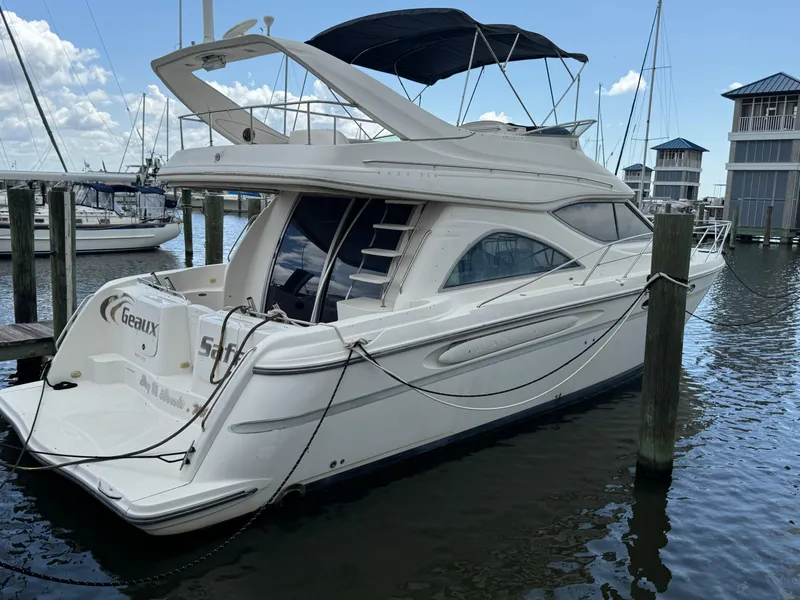 Slide: The Image of 1998 Maxum 4600 SCB yacht docked at marina, featuring sleek design and spacious deck. - 2