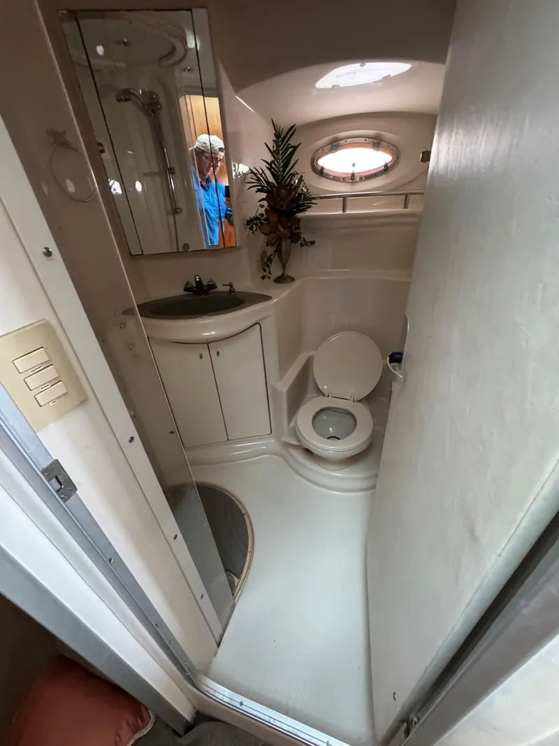 Slide: The Image of Bathroom interior of 1998 Maxum 4600 SCB yacht, featuring sink, toilet, and porthole window. - 26