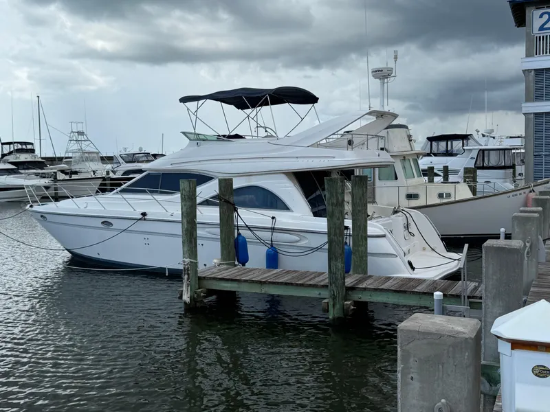 Slide: The Image of 1998 Maxum 4600 SCB yacht docked at marina under cloudy skies. - 3