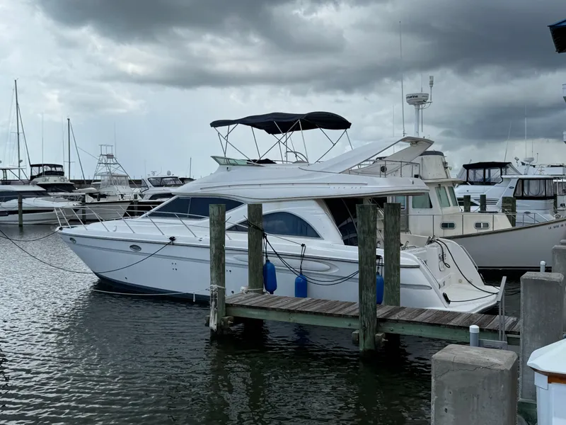 Slide: The Image of 1998 Maxum 4600 SCB yacht docked at marina under cloudy skies. - 4