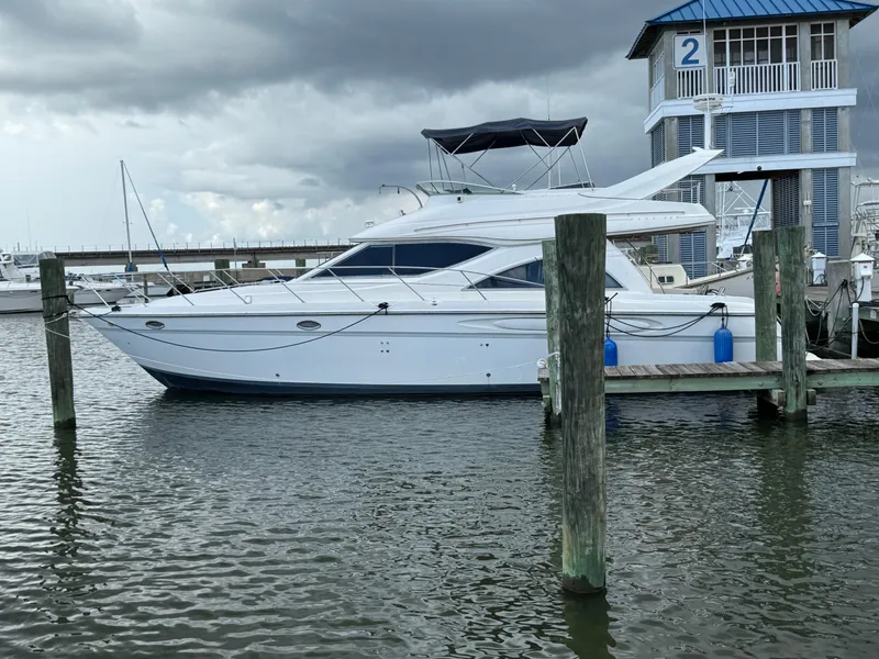 Slide: The Image of 1998 Maxum 4600 SCB yacht docked at marina under cloudy skies. - 5