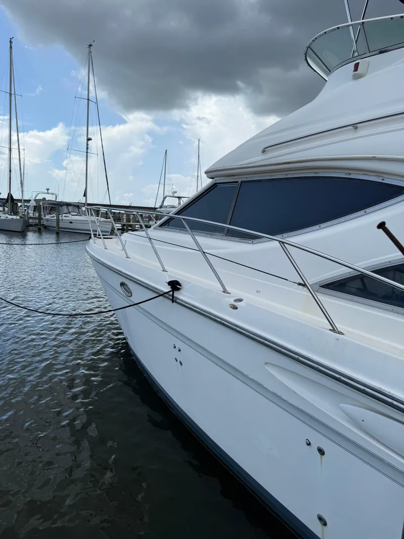 Slide: The Image of 1998 Maxum 4600 SCB yacht docked at marina under cloudy sky. - 6