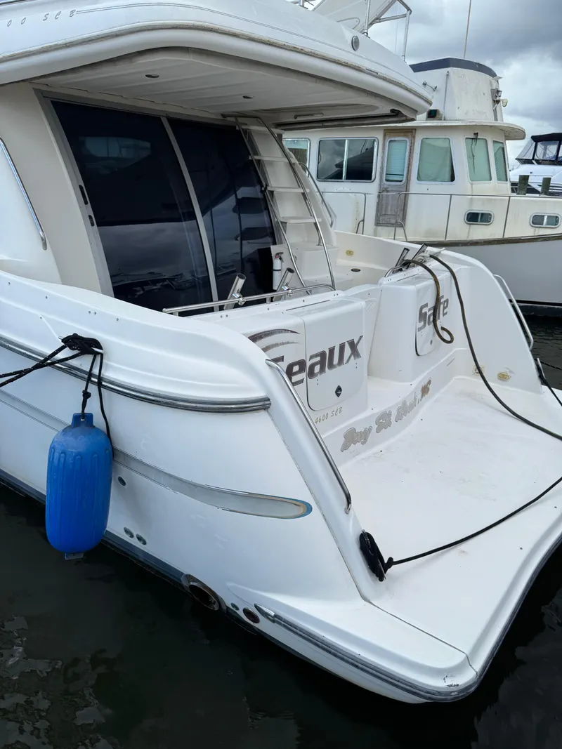 Slide: The Image of 1998 Maxum 4600 SCB yacht docked, featuring sleek white design and blue fender. - 7