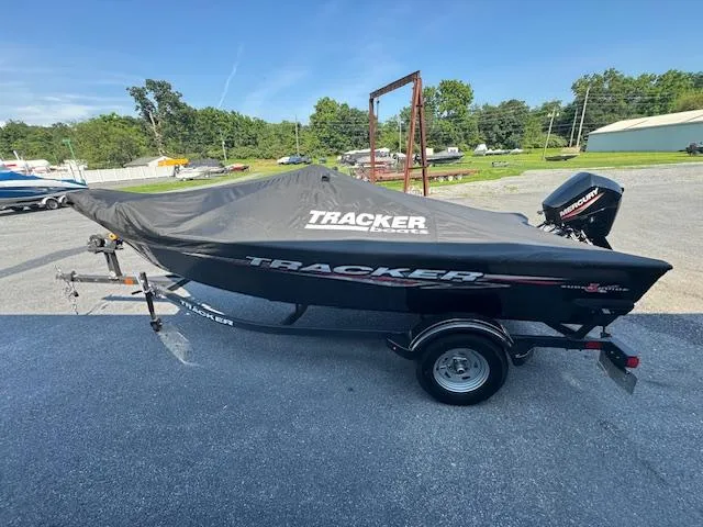 Slide: The Image of 2024 Tracker Super Guide V-16 SC boat with cover on trailer, parked outdoors. - 7
