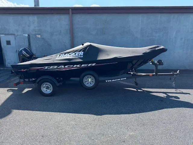 Slide: The Image of 2024 Tracker Super Guide V-16 SC boat on trailer, covered, parked outdoors. - 9