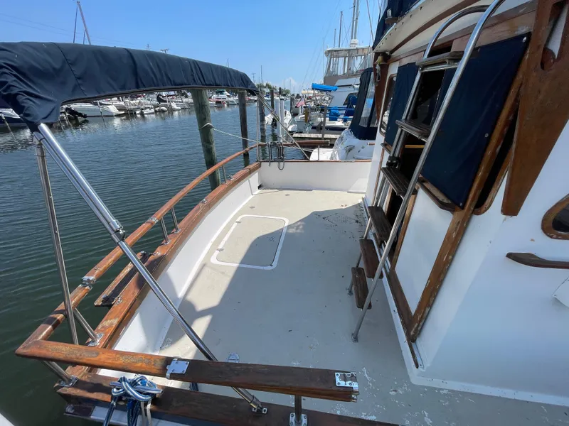 Slide: The Image of 1982 Californian 34 LRC yacht deck with wooden railings and marina view. - 10