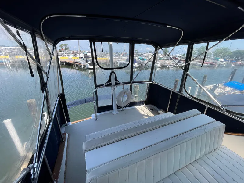 Slide: The Image of 1982 Californian 34 LRC yacht interior with marina view, featuring white seating and clear windows. - 18