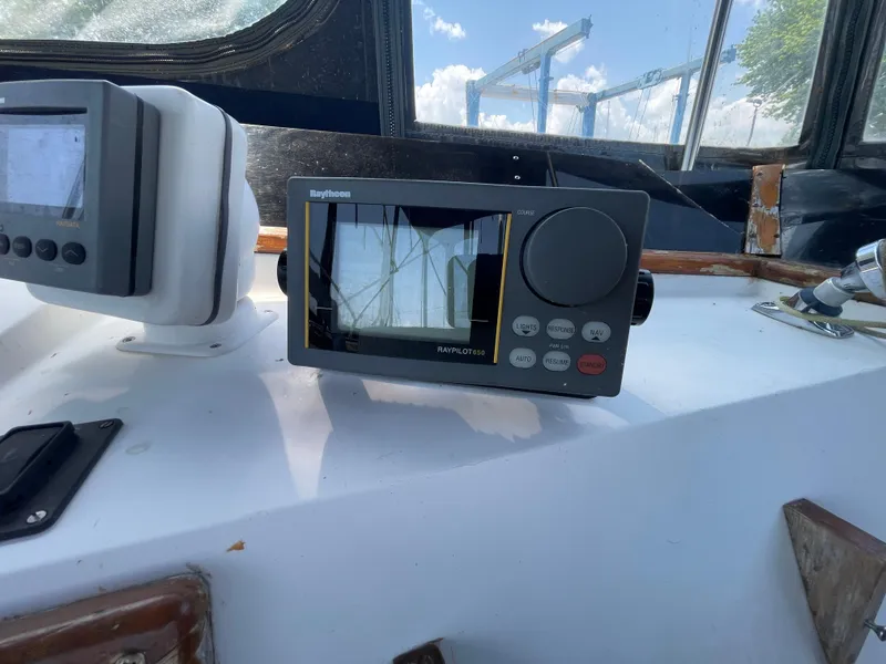 Slide: The Image of Raytheon autopilot system on 1982 Californian 34 LRC boat dashboard, under clear sky. - 19