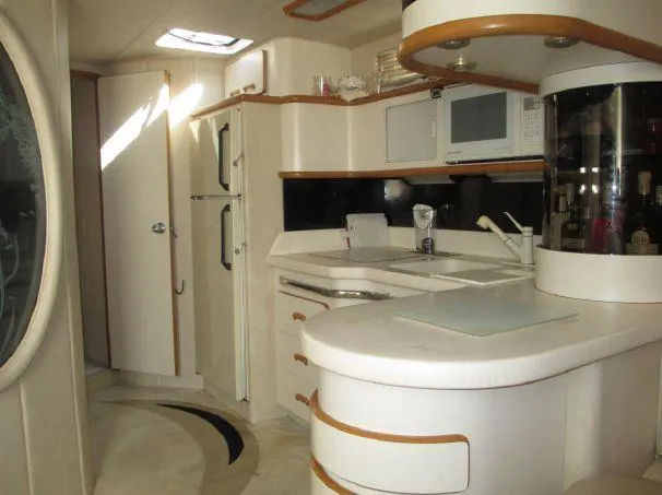Slide: The Image of Interior of 1994 Sea Ray 500 Sundancer yacht, featuring a modern kitchen area. - 11