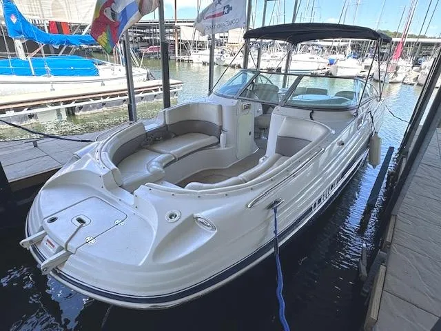 Slide: The Image of 2003 Four Winns 264 Funship boat docked in marina, featuring spacious seating and canopy. - 2