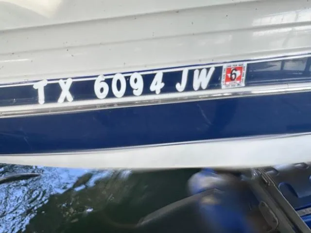 Slide: The Image of 2003 Four Winns 264 Funship boat with registration TX 6094 JW on blue and white hull. - 24