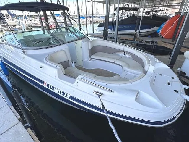 Slide: The Image of 2003 Four Winns 264 Funship boat docked in marina, featuring spacious seating and sleek design. - 3