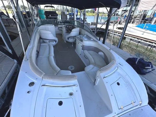 Slide: The Image of 2003 Four Winns 264 Funship boat interior with spacious seating and helm, docked at marina. - 4