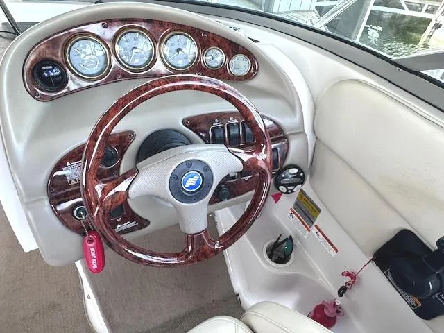 Slide: The Image of 2003 Four Winns 264 Funship dashboard with wood accents and steering wheel. - 6
