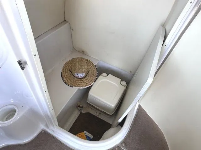 Slide: The Image of 2003 Four Winns 264 Funship boat interior with portable toilet and straw hat. - 9