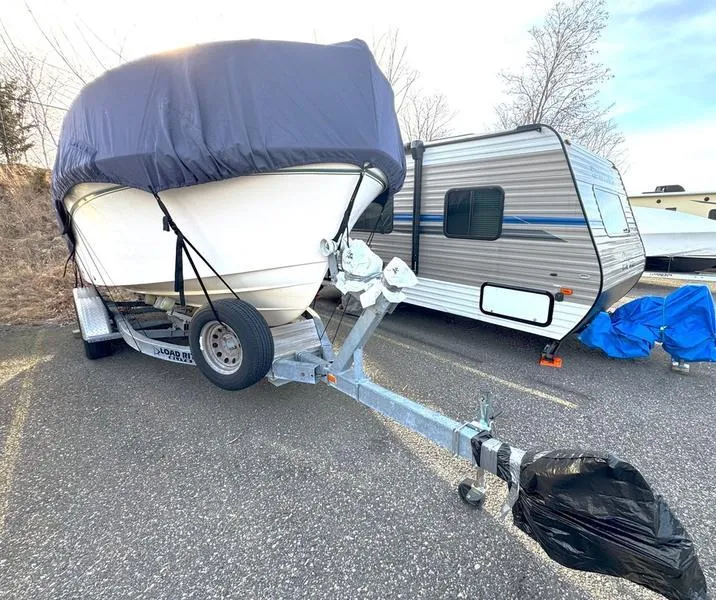 Slide: The Image of 2011 Grady-White 208 Adventure boat on trailer, covered, parked beside a camper. - 14
