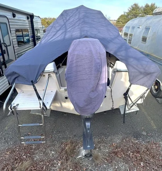 Slide: The Image of 2011 Grady-White 208 Adventure boat covered, parked near RVs and trailers. - 17
